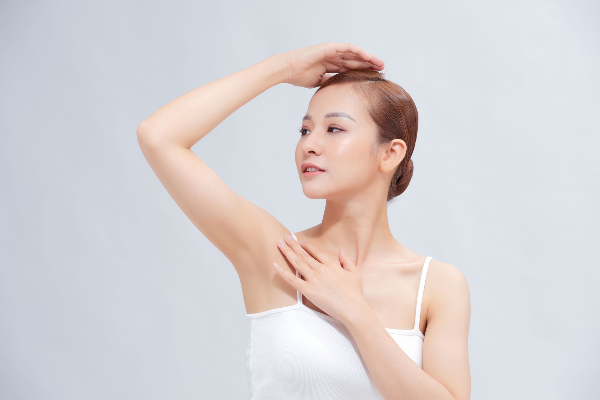 Beautiful Young Asian woman lifting hands up to show smooth armpit cleanliness and protection concept